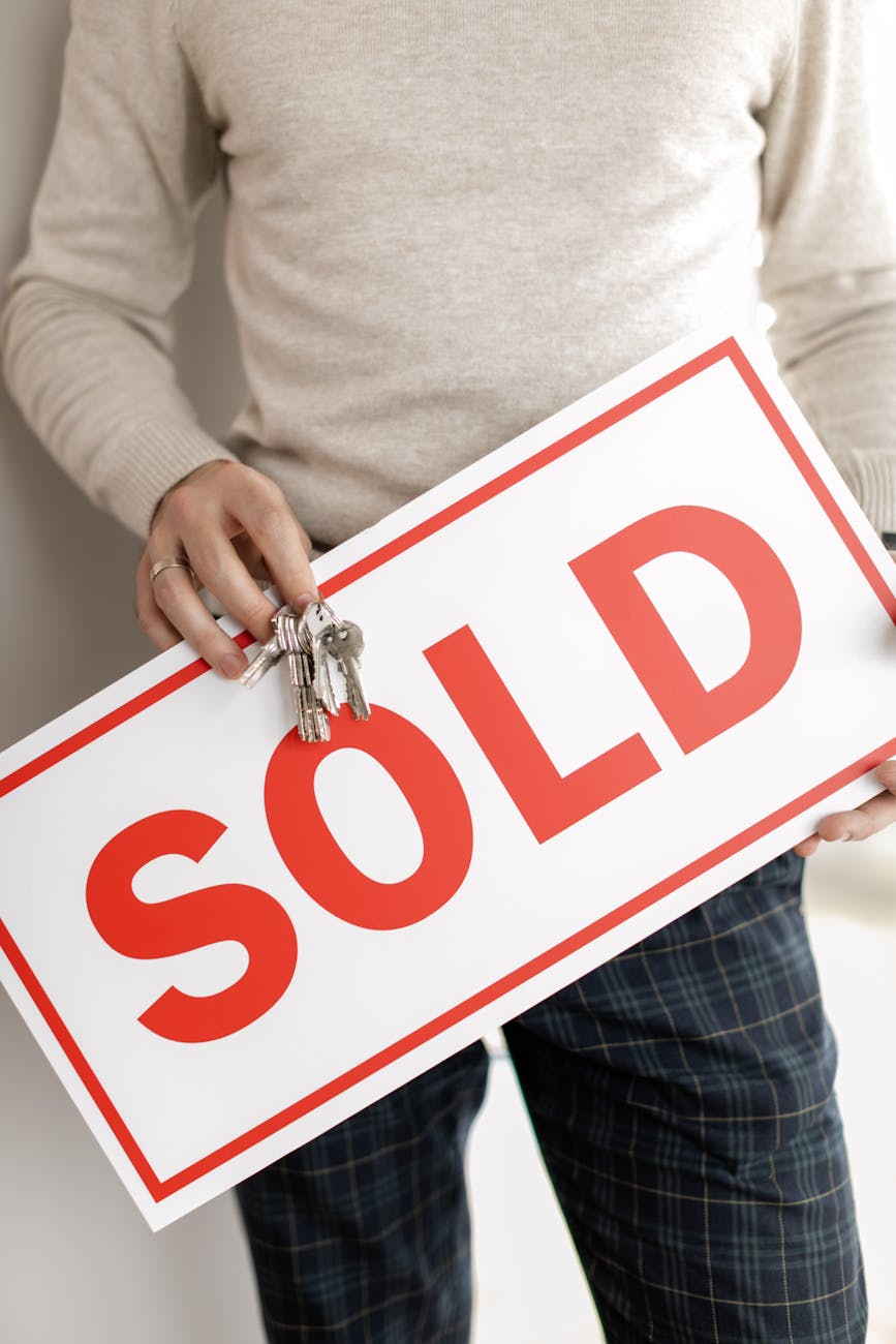 person holding keys and signboard
